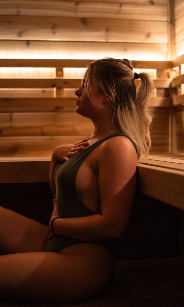 Woman meditating peacefully in MindFuel's sauna, emphasizing relaxation and mindfulness.