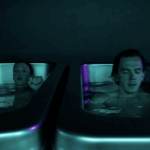 Two people in cold plunge tubs at MindFuel under moody teal and purple lighting, practicing breathwork and contrast therapy for recovery and stress relief.
