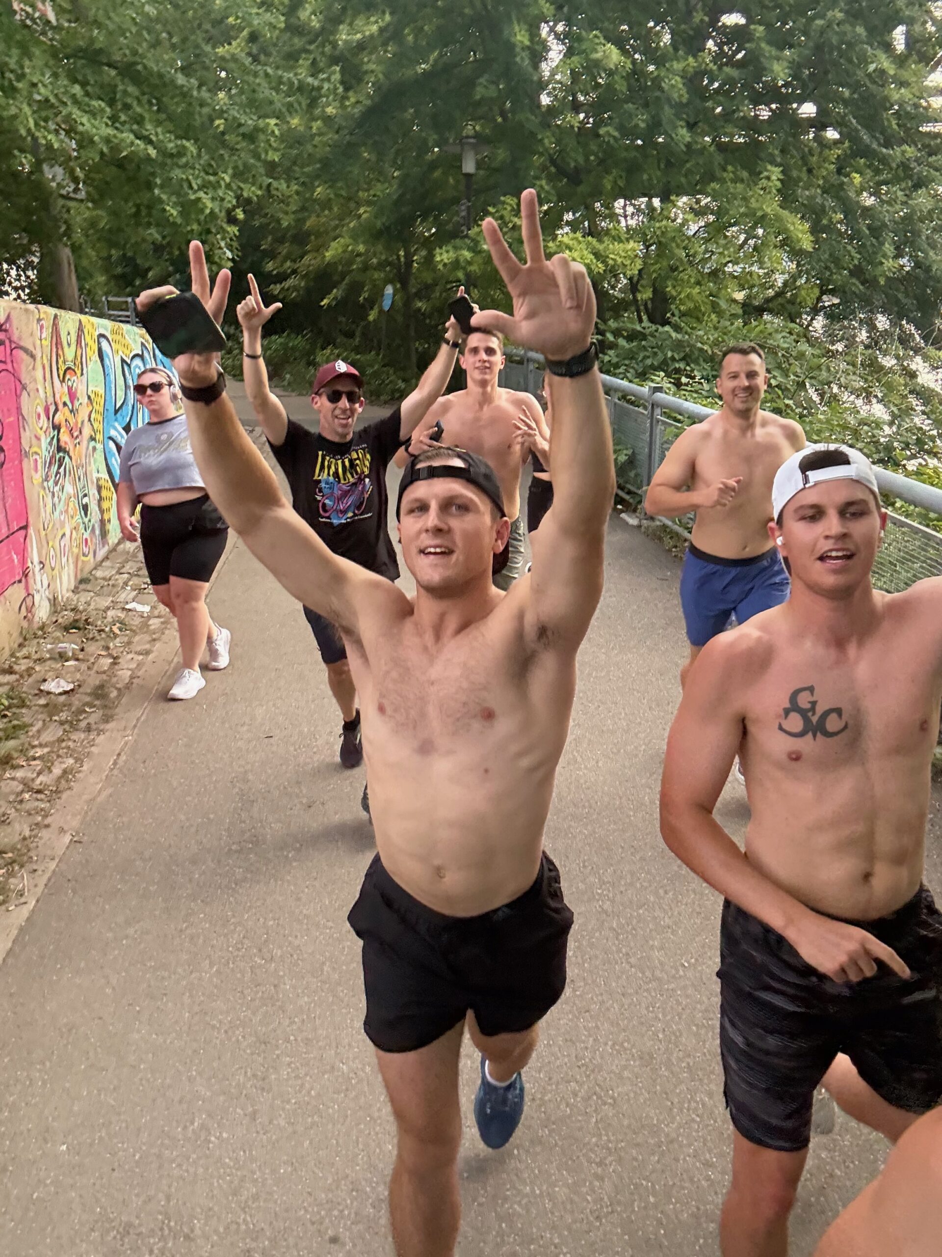Run Club crew running through Pittsburgh with arms raised