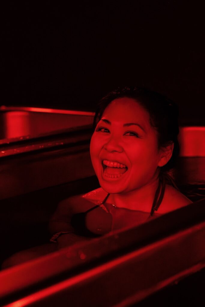Woman smiling in cold plunge tub at MindFuel Method in Pittsburgh